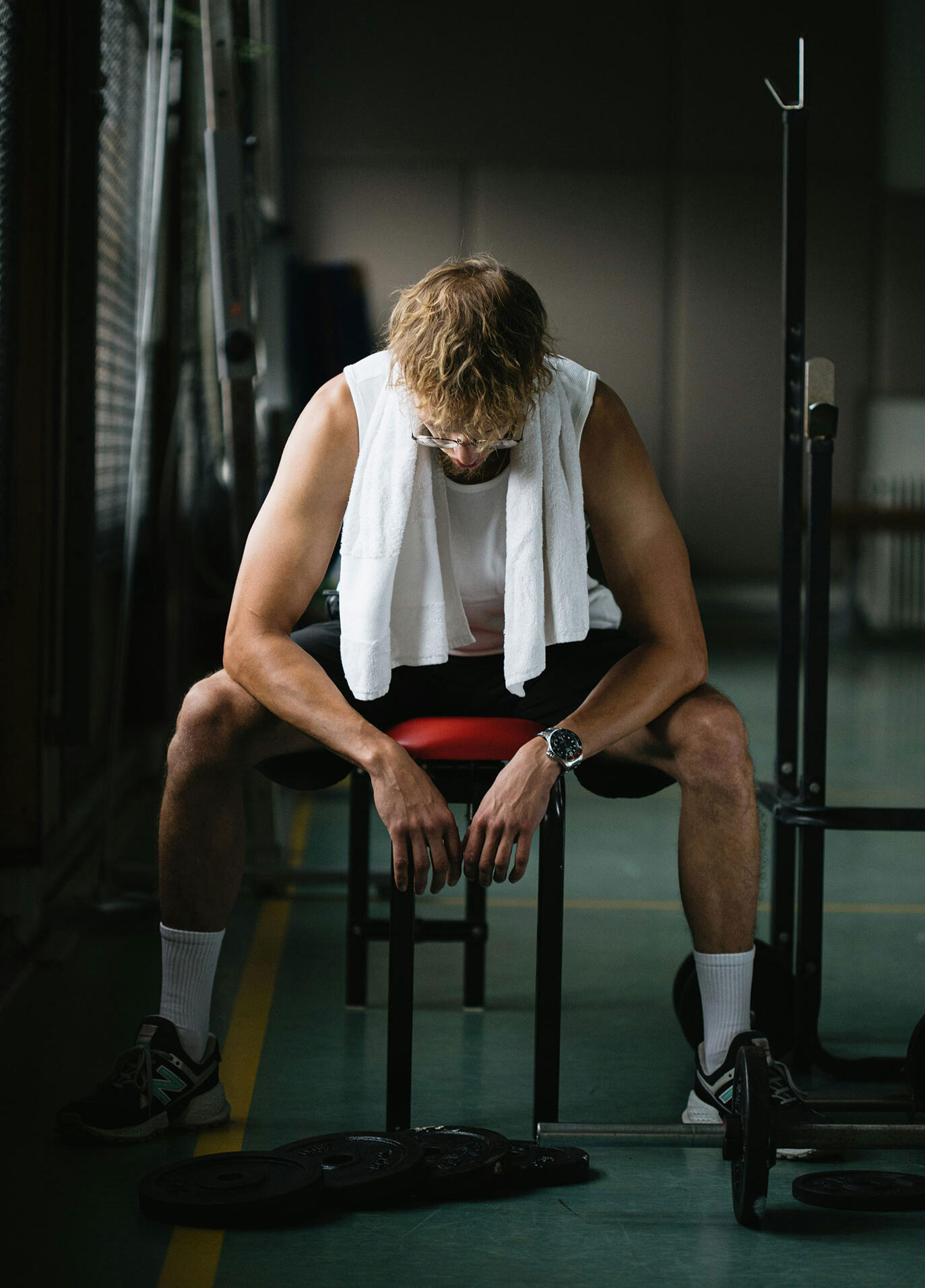 Deportista sentado en el vestuario reflexionando antes o después de la competición, momento emocional ligado a la mentalidad.